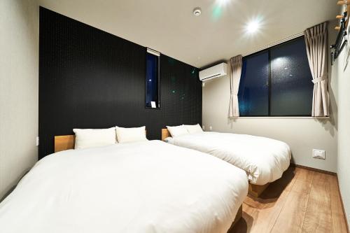 木更津市にあるRakuten STAY HOUSE 木更津の窓付きの客室で、白いベッド2台が備わります。
