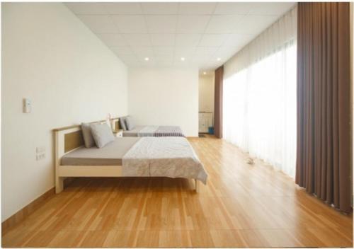 a bedroom with a bed and a wooden floor at Gia Trinh Farmstay Ba Vi - Venuestay in Hanoi