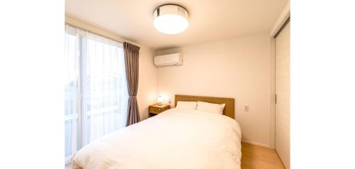 um quarto com uma cama e uma grande janela em Rakuten STAY HOUSE x WILL STYLE Fujinomiya 101 em Fujinomiya