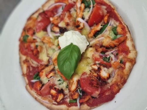 a pizza with a green leaf on a white plate at Ten Dollar Town Motel in Gulgong