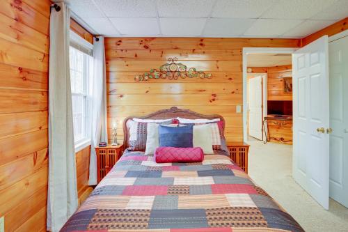 ein Schlafzimmer mit einem Bett in einem Zimmer mit Holzwänden in der Unterkunft Deer Hollow in Ellijay