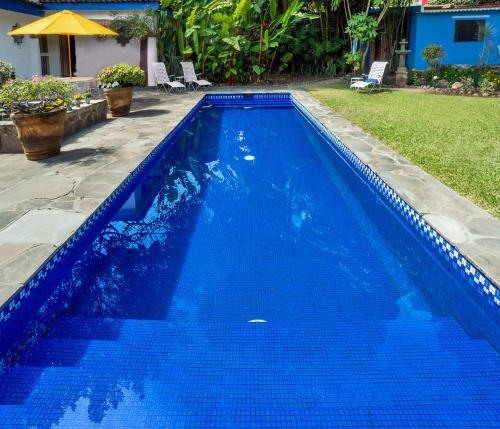 a blue swimming pool with blue water in a yard at Garden of Dreams Boutique Hotel in Ajijic