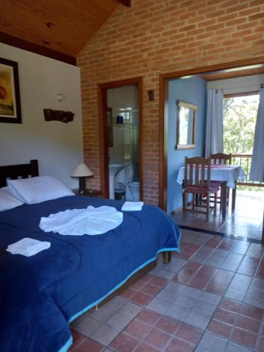 Schlafzimmer mit einem Bett, einem Tisch und Stühlen in der Unterkunft Caminho do Sol in Monte Verde