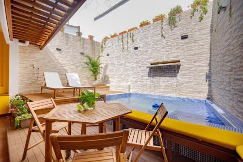 patio ze stołem i krzesłami oraz basenem w obiekcie Casa Marta by Soho w mieście Cartagena de Indias