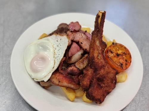 a plate of breakfast food with an egg and bacon at Ten Dollar Town Motel in Gulgong
