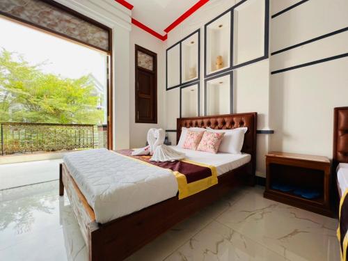 a bedroom with a bed and a large window at Đại Quang Hotel in Can Tho