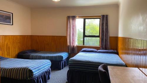 a hotel room with two beds and a window at National Park Backpackers in National Park