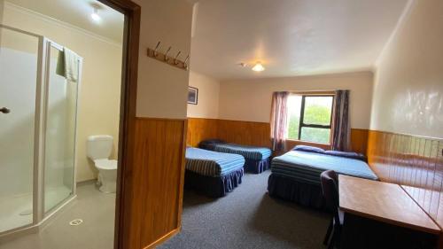 a hotel room with two beds and a toilet at National Park Backpackers in National Park