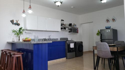 - une cuisine avec un îlot bleu dans l'établissement Juan Dolio - Hermoso y acogedor apartamento, à Juan Pedro