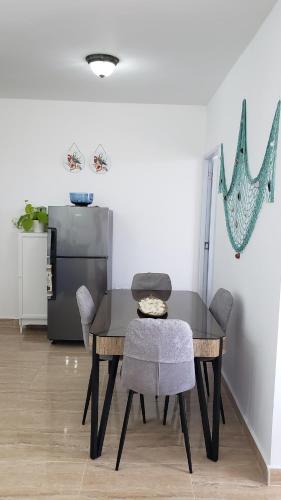 d'une table à manger avec des chaises et un réfrigérateur. dans l'établissement Juan Dolio - Hermoso y acogedor apartamento, à Juan Pedro