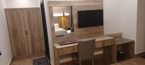 a room with a desk with a bed and a mirror at المكارم بارك للشقق المخدومة -درجة التصنيف- اقتصادية in Jeddah