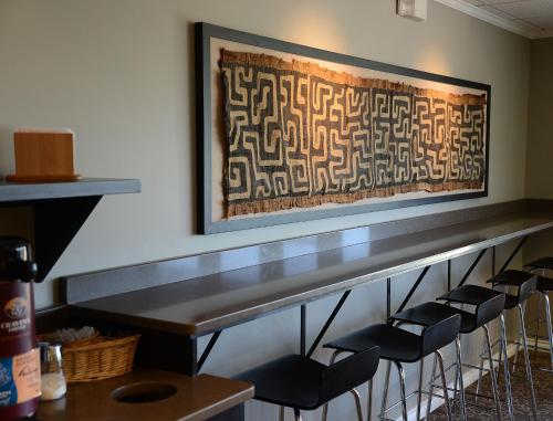 a bar with stools and a large painting on the wall at The Madison Inn in Spokane