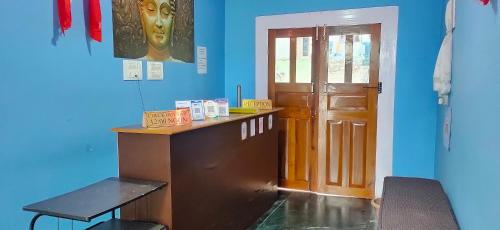 a blue room with a desk and a door at The Lachung Inn in Lachung