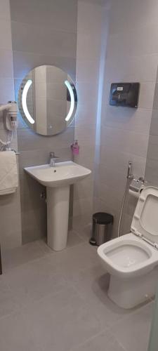 a bathroom with a sink and a toilet and a mirror at المكارم بارك للشقق المخدومة -درجة التصنيف- اقتصادية in Jeddah