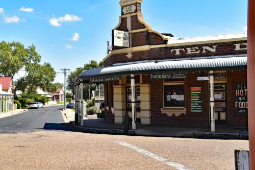 a building on the side of a street with a clock tower at Ten Dollar Town Motel in Gulgong