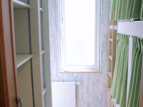 a bathroom with a window and a shower curtain at Ocho Guest House in Sapporo
