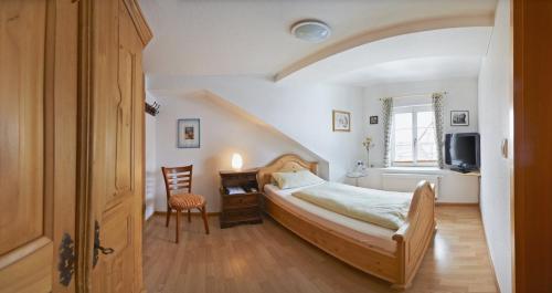 Schlafzimmer mit einem Bett, einem Schreibtisch und einem TV in der Unterkunft Grafs Adler in Offenburg