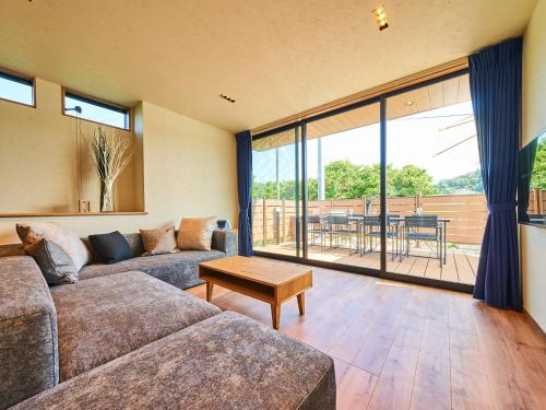 a living room with a couch and a table at Rakuten STAY HOUSE Kujukuri Ichinomiya 101 3LDK with BBQ terrace in Ichinomiya