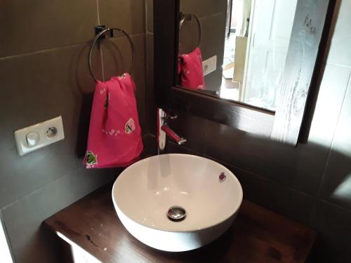 La salle de bains est pourvue d'un lavabo blanc et d'un sac rose. dans l'établissement ROYAL VAI, à Fa'a'ā