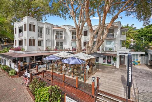 een luchtzicht op een gebouw met tafels en parasols bij Alassio Beachfront Apartments Palm Cove in Palm Cove