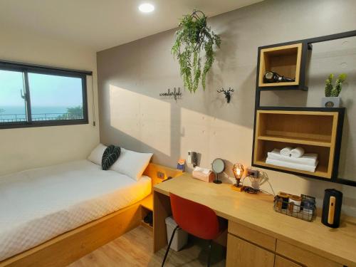 a bedroom with a desk and a bed and a desk at 濱境行旅 Begin Inn in Xiaoliuqiu