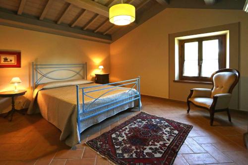 a bedroom with a bed and a chair and a window at Agriturismo La Dolce Vista in Poppi