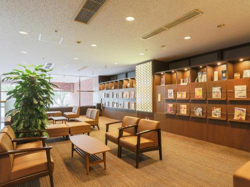 a waiting room with chairs and tables and a plant at Hotel Wing International Nagoya in Nagoya