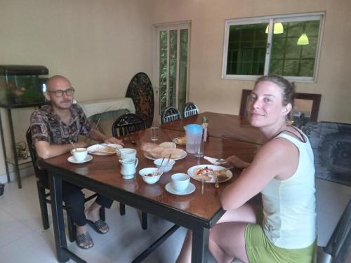 a man and a woman sitting at a table with food at Traveller's Villa in Hatton