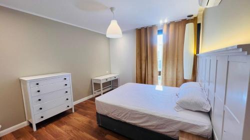 1 dormitorio con cama blanca y vestidor en Sodic Westown Residence 2, en Seis de Octubre