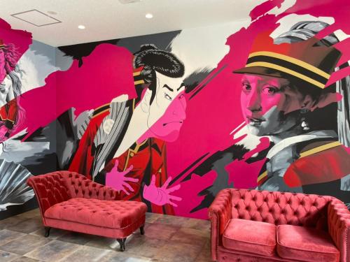 - une peinture murale dans une chambre avec 2 chaises et un canapé dans l'établissement New Normal Hotel in NAMINOUE ニューノーマルホテルイン波の上, à Naha