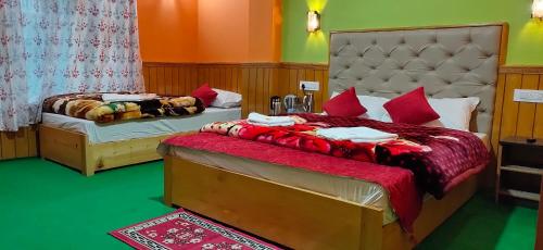 a bedroom with two beds with red pillows at The Lachung Inn in Lachung