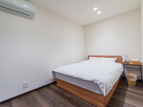 Rakuten STAY HOUSE x WILL STYLE Sasebo 109 في ساسيبو: غرفة نوم بسرير ذو شراشف بيضاء