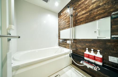 a bathroom with a shower and a tub and a sink at Rakuten STAY Osaka Station North Deluxe Fourth in Osaka