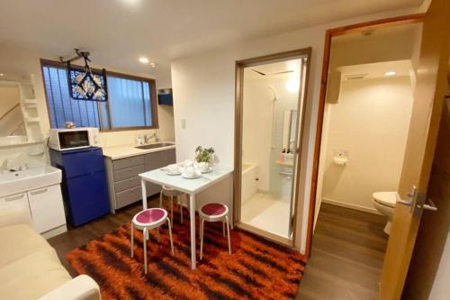 ein Badezimmer mit einem kleinen Tisch und zwei Hockern in der Unterkunft Takemura Building106 in Tokio