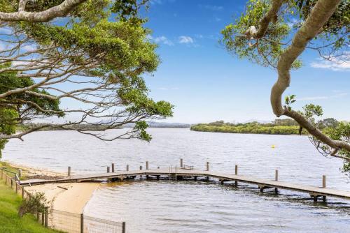 a dock on a lake with trees in the foreground at Boronia Avenue 18 in Mylestom