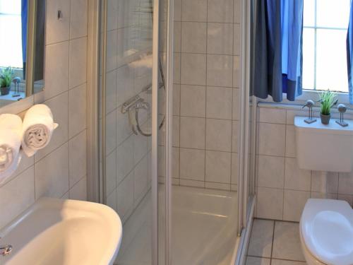 a bathroom with a shower and a sink and a toilet at Ferienhaus Nr 102, Kategorie Komfort, Feriendorf Hochbergle, Allgäu in Karlsebene
