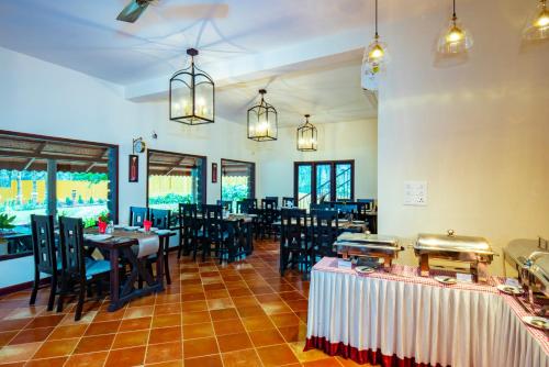a dining room with tables and chairs and chandeliers at Vaikundam Legacy in Kaliyal