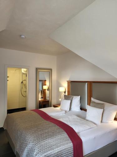 ein Schlafzimmer mit einem großen weißen Bett mit weißen Kissen in der Unterkunft Hotel Restaurant Alte Stadtmauer in Beilstein