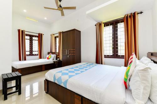 a bedroom with two beds and a ceiling fan at CentreHome Villa Wayanad in Meenangadi