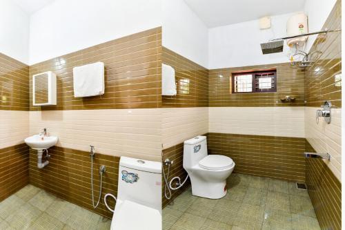 a bathroom with a toilet and a sink at CentreHome Villa Wayanad in Meenangadi