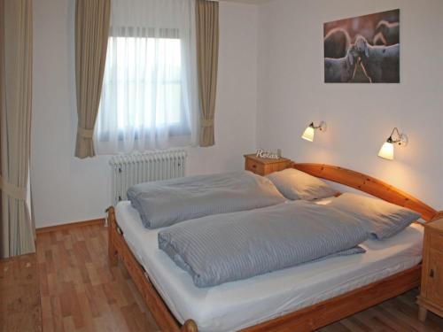 um quarto com 2 camas e uma janela em Ferienhaus Nr 110, Kategorie Komfort, Feriendorf Hochbergle, Allgäu em Karlsebene