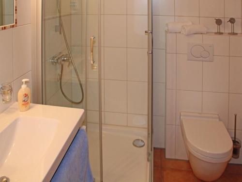 uma casa de banho com um chuveiro, um WC e um lavatório. em Ferienhaus Nr 110, Kategorie Komfort, Feriendorf Hochbergle, Allgäu em Karlsebene