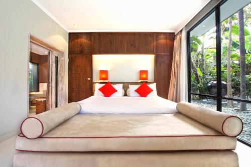 a bedroom with a large bed with a large window at Segara Village Hotel in Sanur