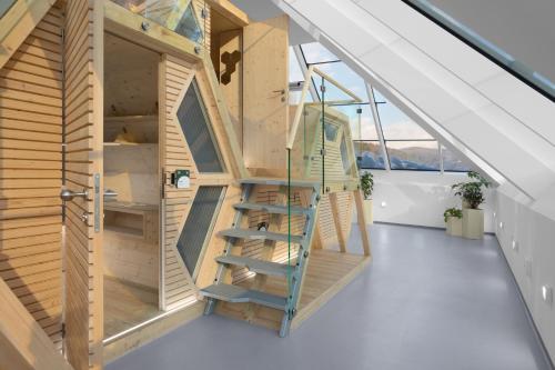 Una casa de madera con una escalera en una habitación en Honeybee Hostel - Hiša kranjske čebele, en Višnja Gora