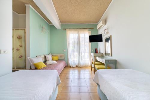 um quarto de hotel com duas camas e um sofá em Agia Markella em Vrontádos