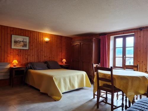 a bedroom with a bed and a table and a window at Charmant Gîte Vosgien avec Terrasse, Randonnées et Lacs, Proche Alsace et Col du Donon - FR-1-584-54 in Bionville
