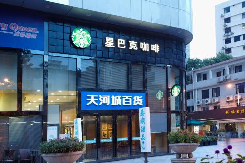 un edificio con un cartel en la parte delantera en Louidon Mega Apartment Hotel Of Kam Rueng Plaza - Sunshine Apartment, en Guangzhou