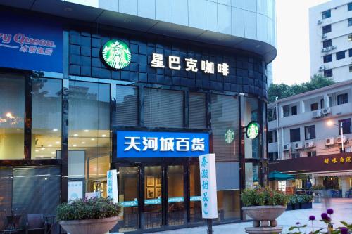 a building with a sign on the front of it at Louidon Mega Apartment Hotel Of Kam Rueng Plaza - Sunshine Apartment in Guangzhou