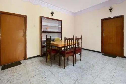 a dining room with a table and chairs in a room at Long Wood Hills Cottage in Ooty