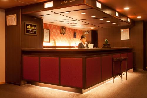 a woman sitting at a bar in a hotel at Matsui-Bekkan Hanakanzashi in Kyoto